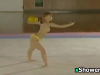 Азіатська athlete performs з оголеними грудьми і зливи